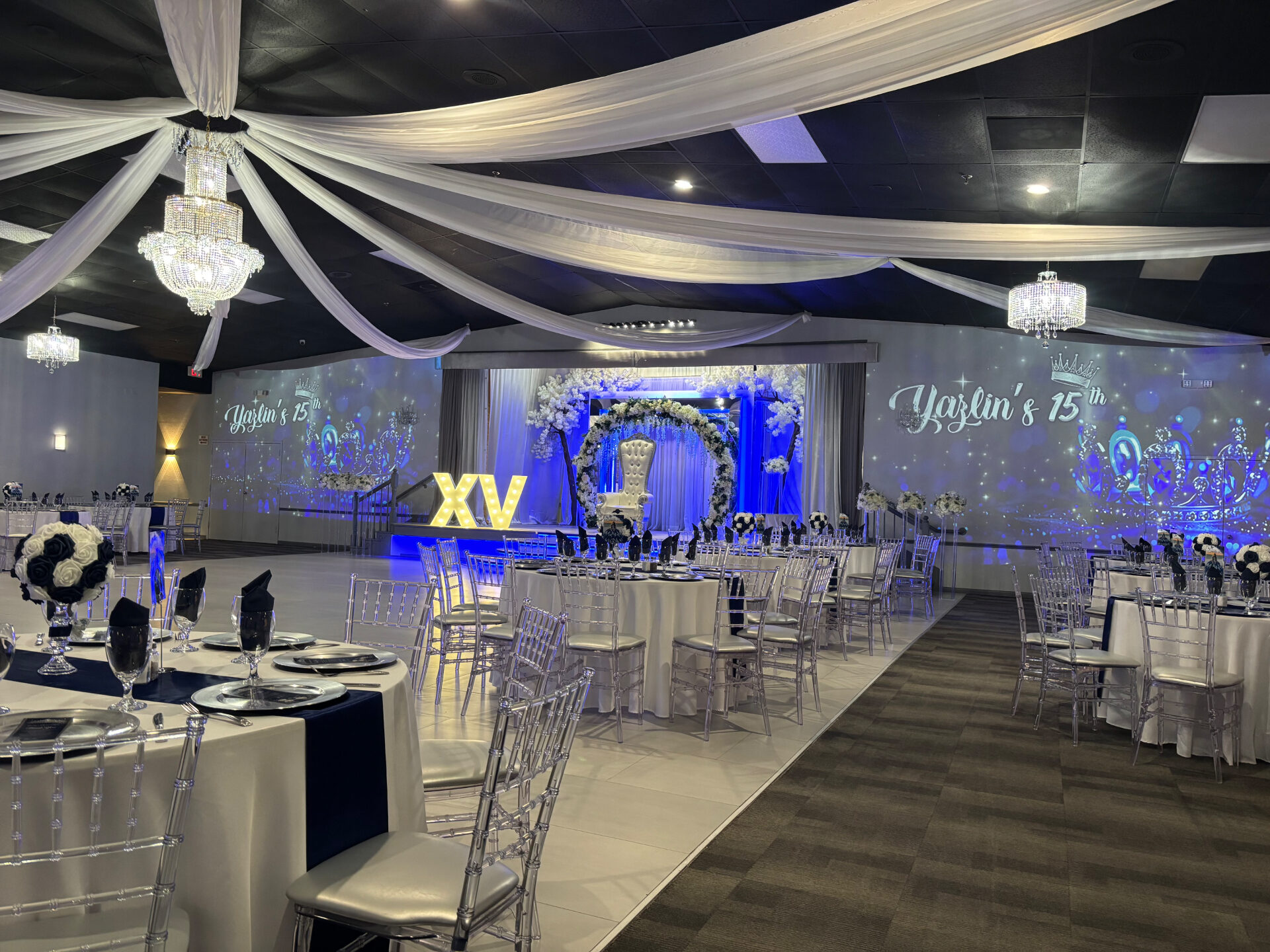 Blue uplighting and chandeliers at a Yazlin's XV celebration