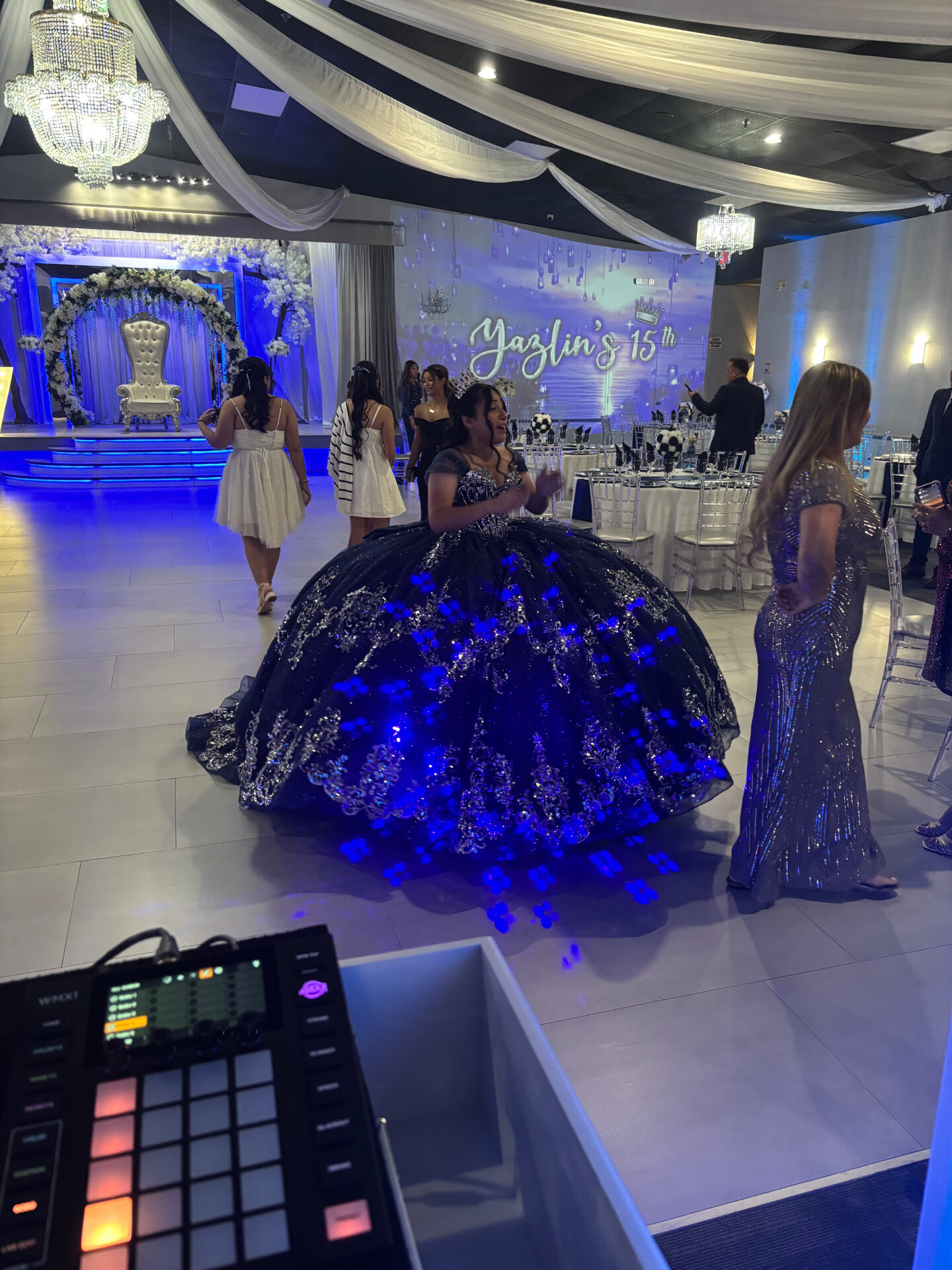Quinceañera in illuminated black ball gown on the dance floor